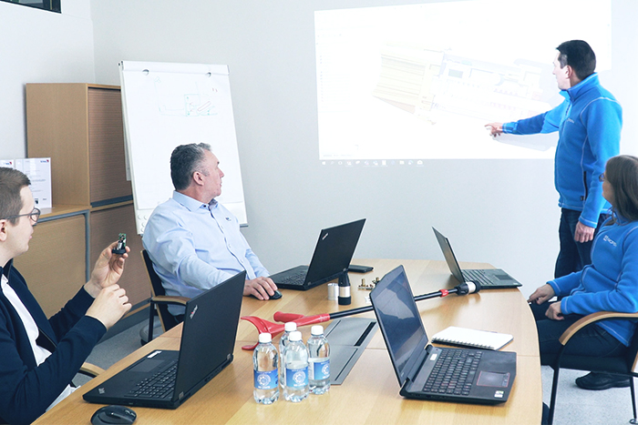Customer-oriented design work. Mechanical designers discuss with the electronics team in a meeting.